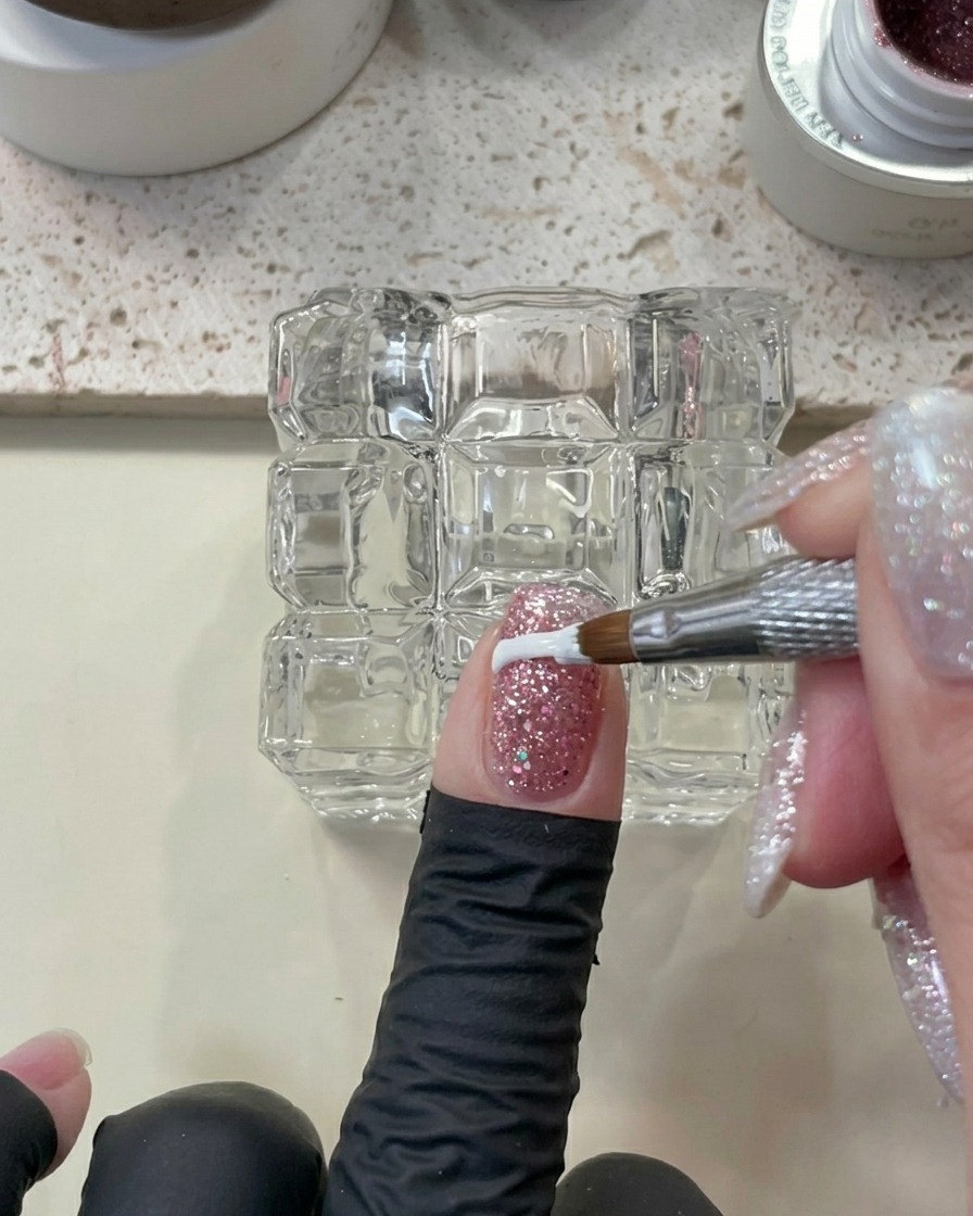 Vue rapprochée dun doigt avec du gel pailleté étant nettoyé avec un outil, prêt pour le processus de catalysation.
