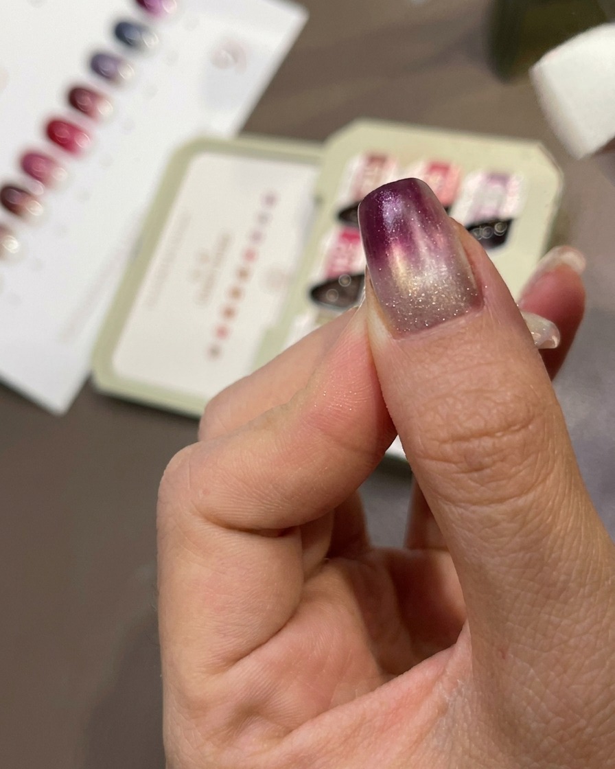 Une éponge tapotant du gel violet sur longle pour créer un effet dégradé.