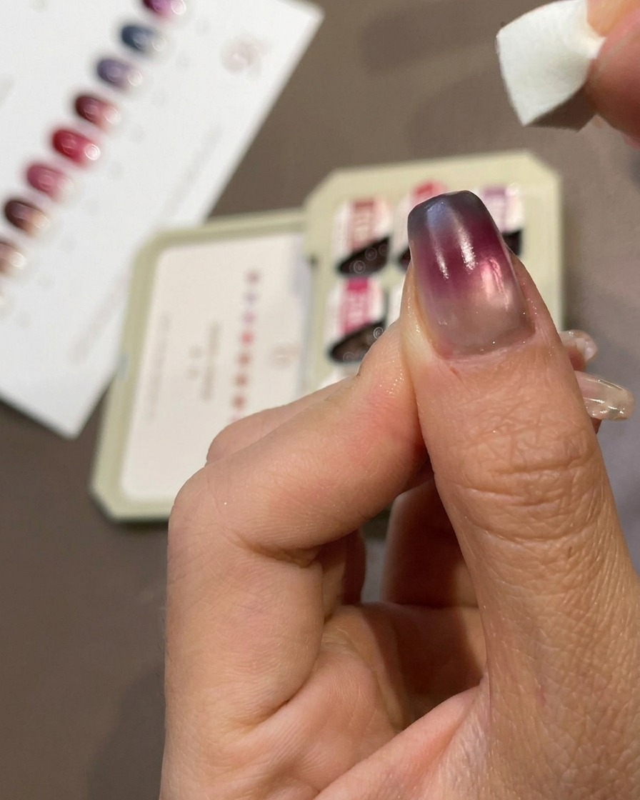 Gros plan dun doigt montrant une petite éponge tapotant du gel bleu sur le bout dun ongle manucuré.