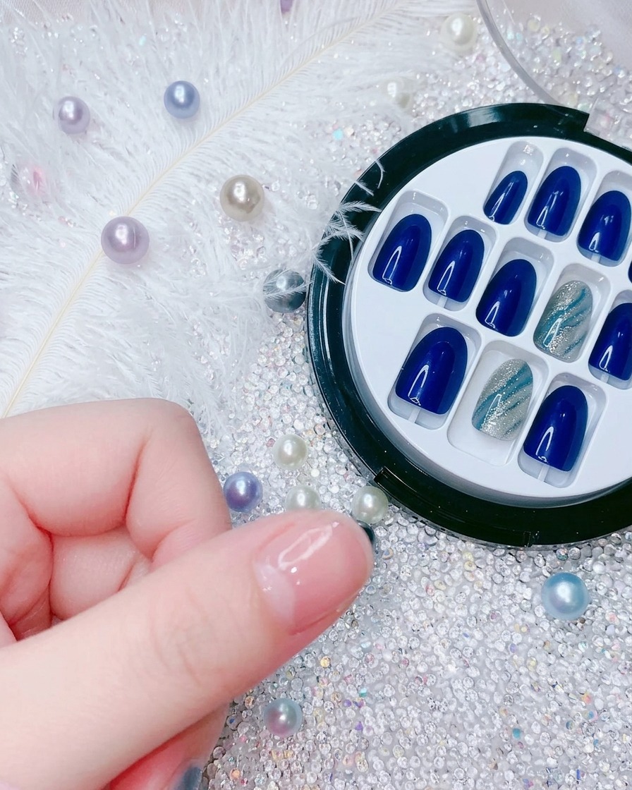Gros plan montrant une main positionnant un nouveau faux ongle bleu électrique sur lindex.