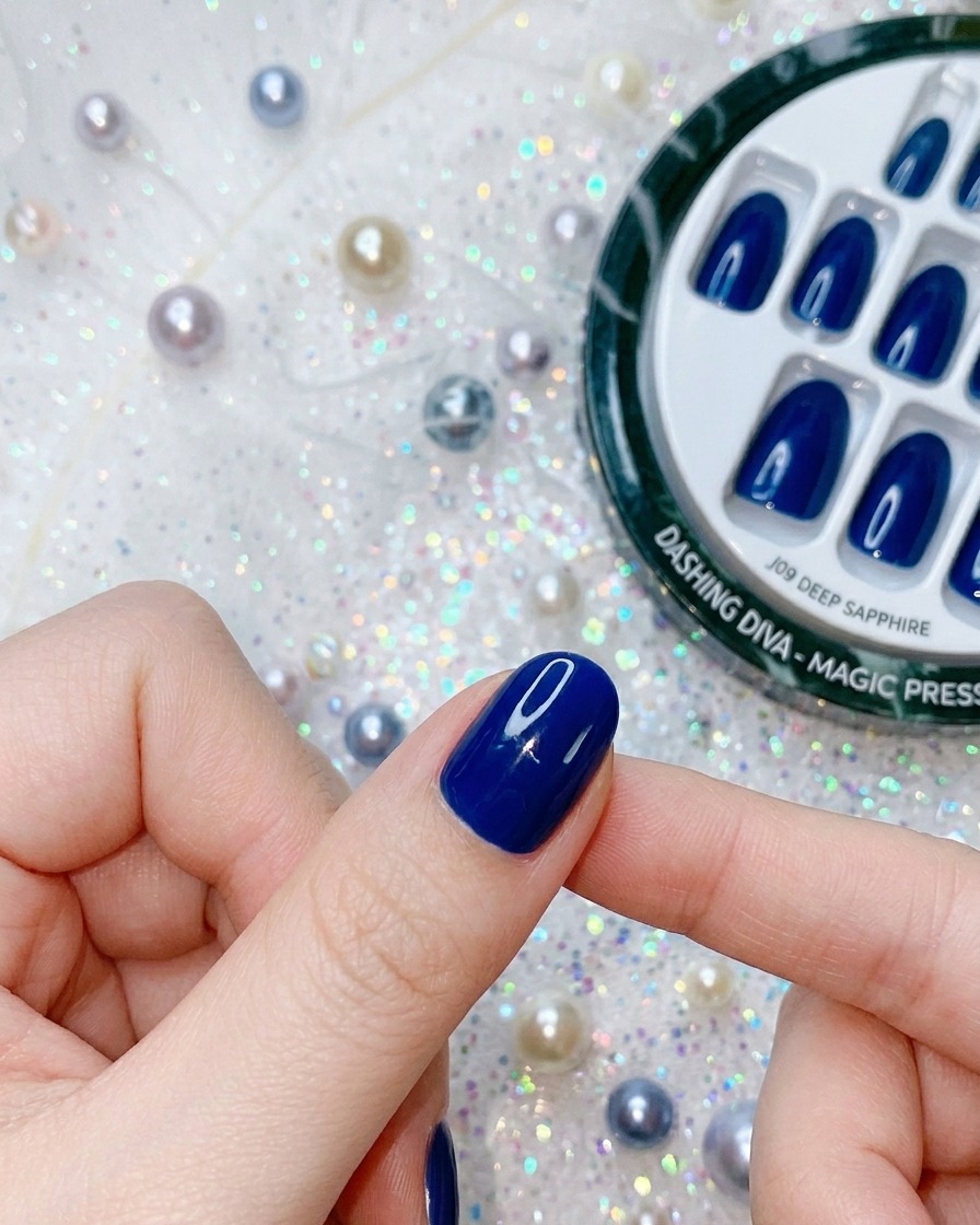 Gros plan dun doigt appliquant une pression sur un faux ongle bleu profond pour finaliser ladhérence.