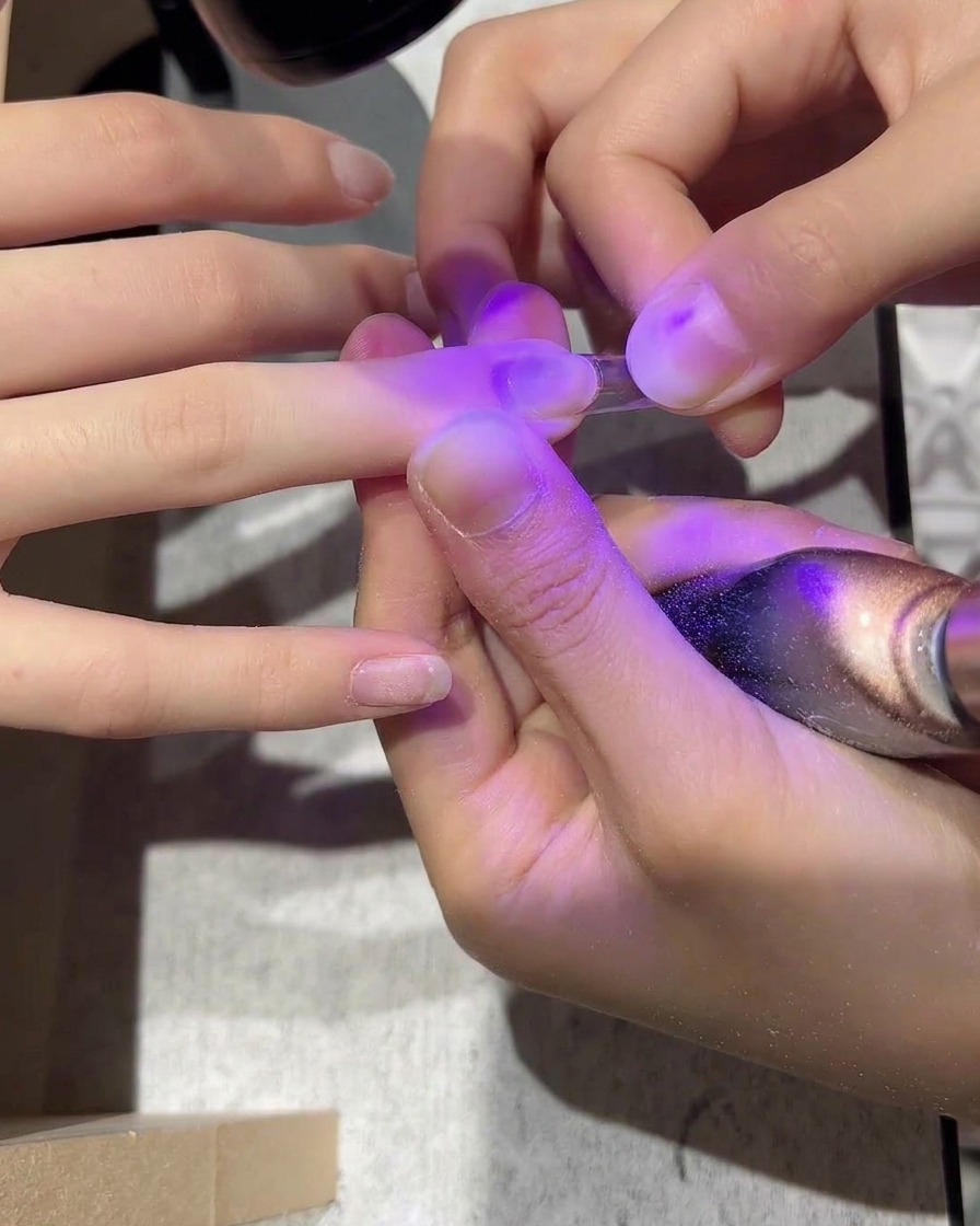 Une capsule transparente appliquée sur un ongle naturel avec de la colle.