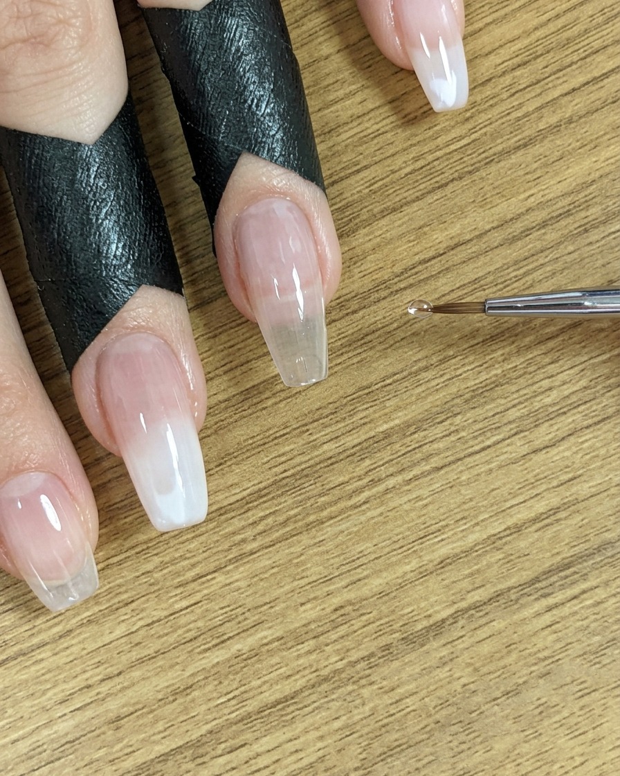 Une petite pointe de pinceau positionnée près des ongles, prête pour létape suivante.