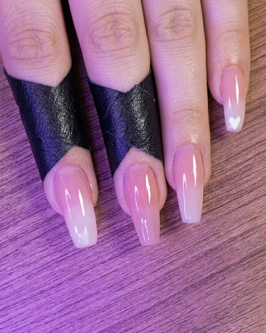 Vue de doigts avec des ongles de couleur nude placés dans une lampe à ongles.