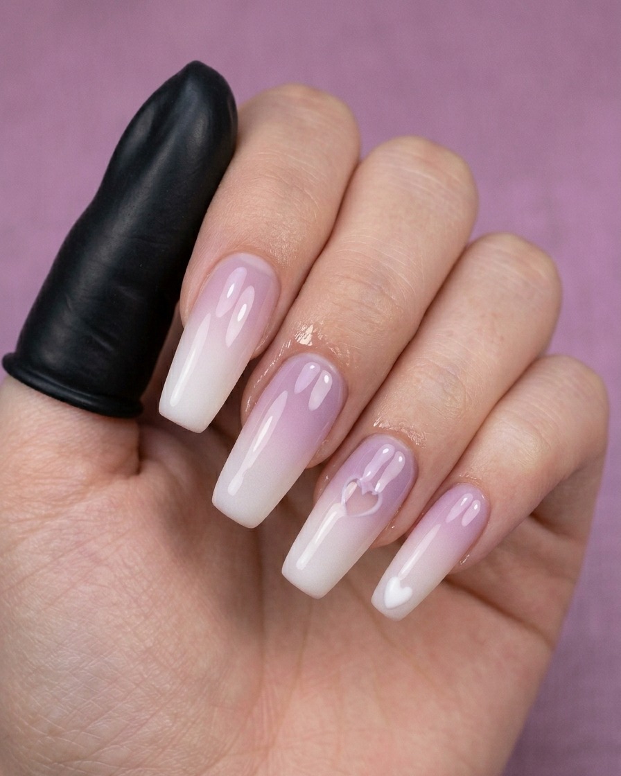 Un gros plan dun outil de dotting créant un petit cœur blanc sur un ongle manucuré.