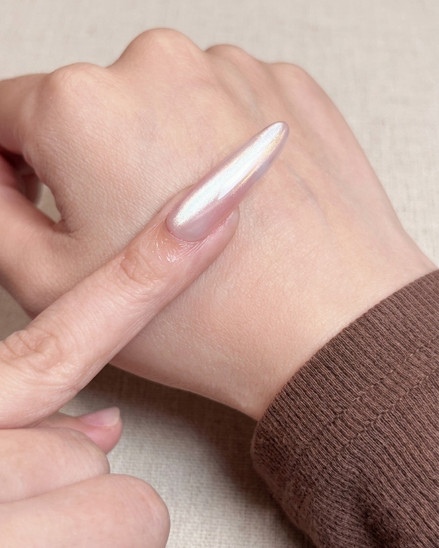 Vue rapprochée dun pinceau appliquant une seconde couche de gel nude pour obtenir une finition opaque et lisse.