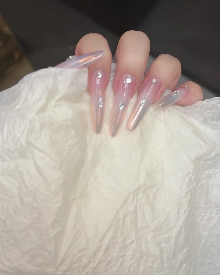 Un pinceau appliquant un gel blush doux au centre de longle.