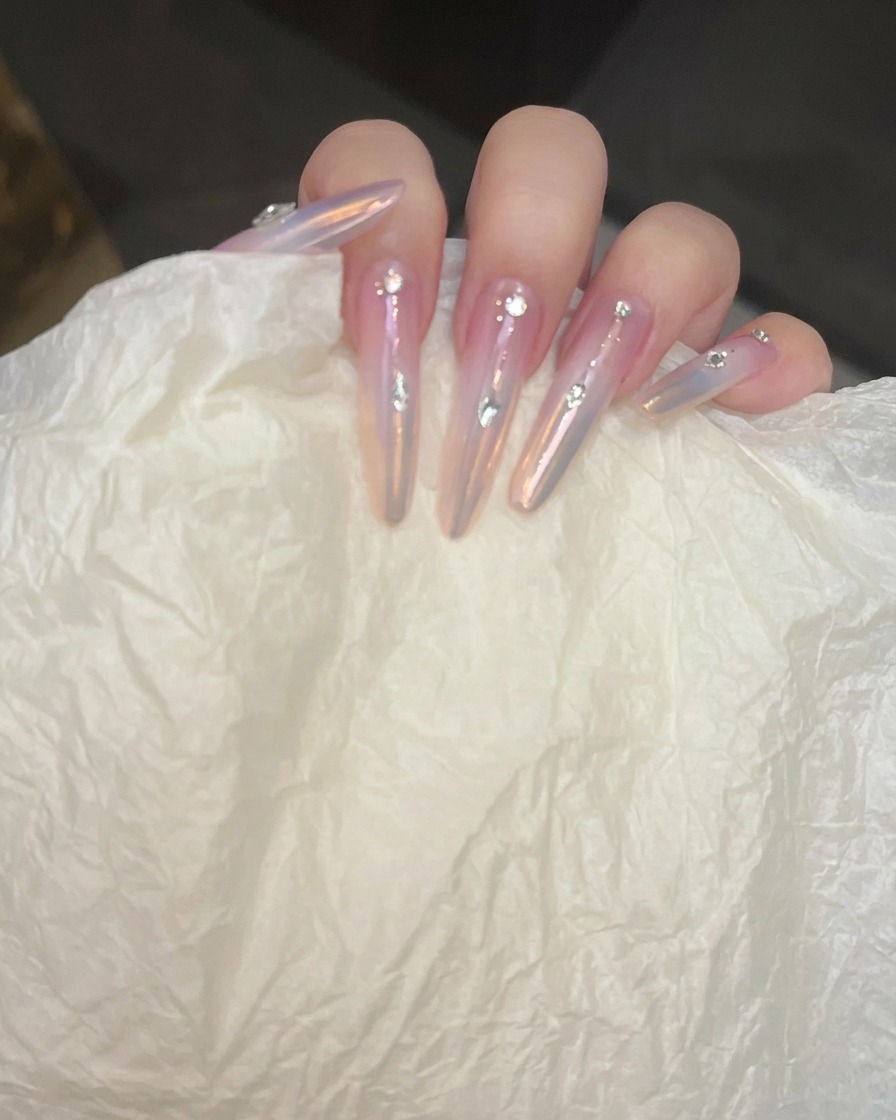 Gros plan sur un ongle où la ligne argentée est nettoyée avec un pinceau fin.