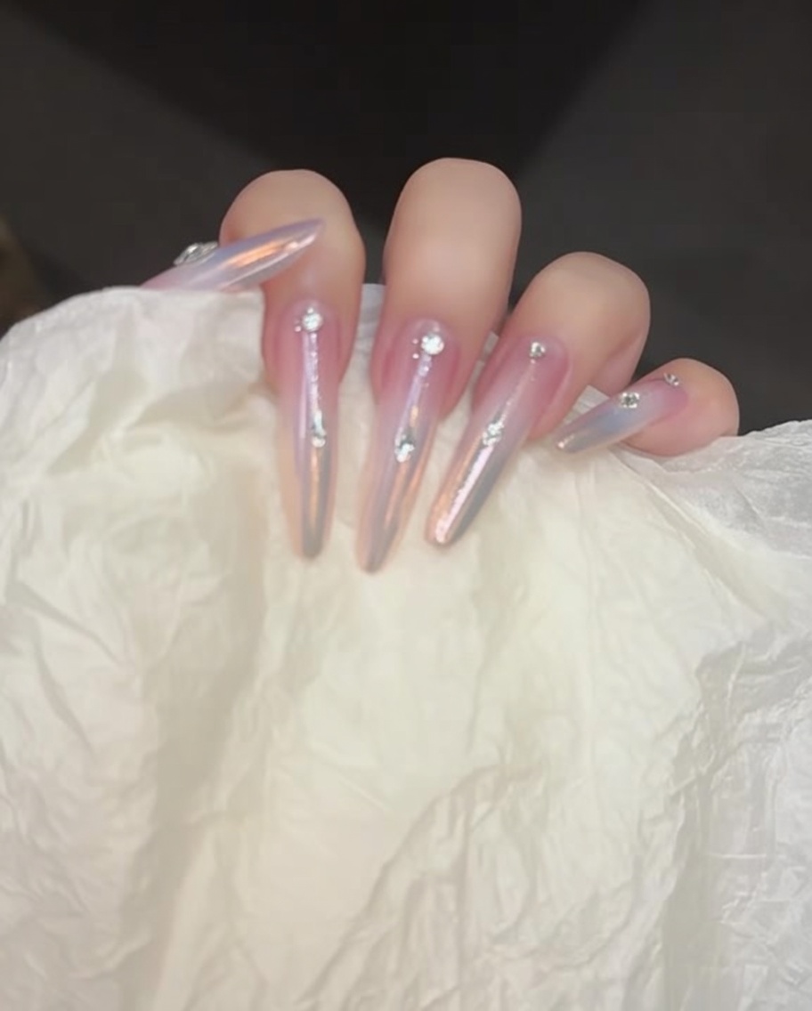 Un outil de saisie plaçant de petits strass sur des gouttes de gel adhésif.