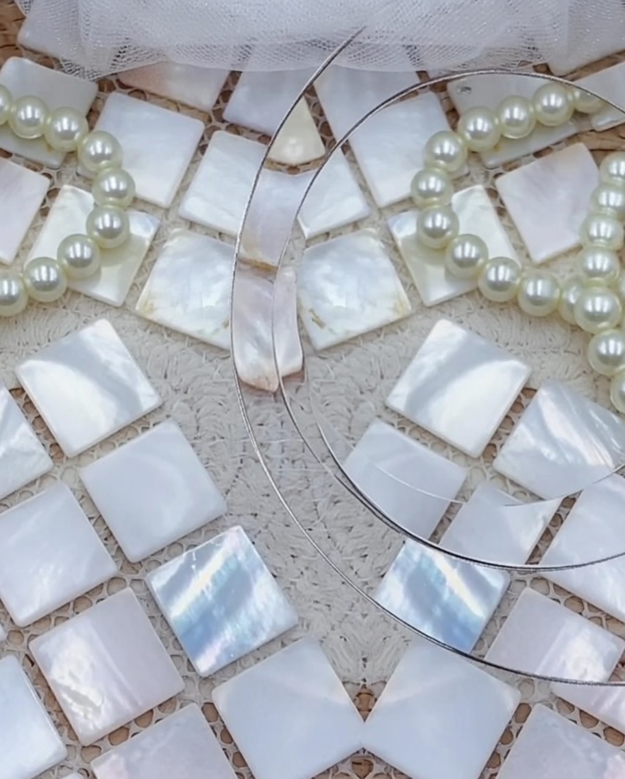 Gros plan du dessous dun ongle press-on décoré avec un adhésif gel transparent en cours dapplication.
