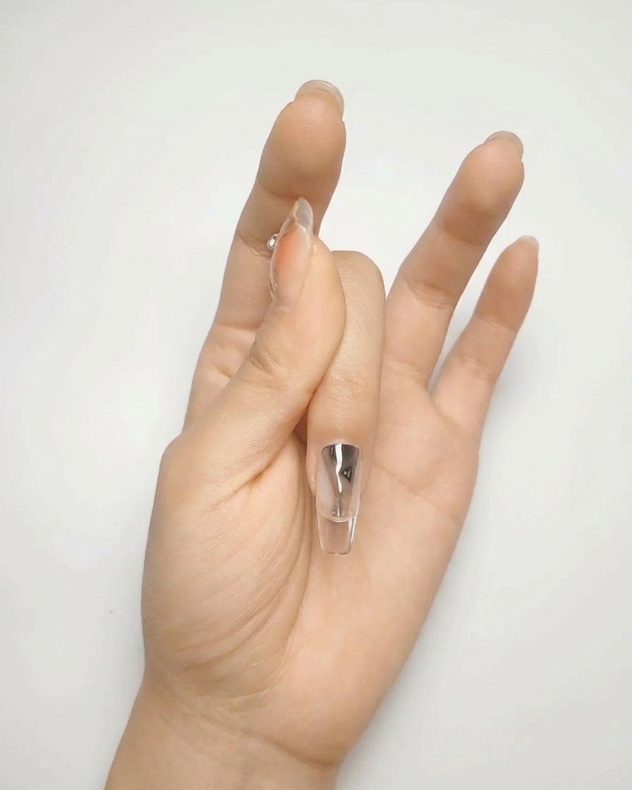 Gros plan dun pinceau appliquant une seconde couche de gel nude pour une surface lisse et opaque.