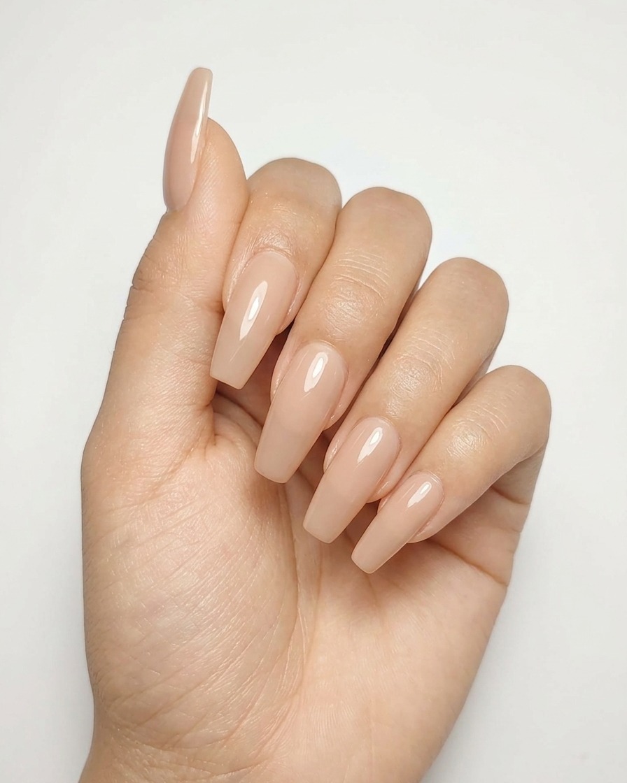 Gros plan dun ongle en gel nude avec un design détoile argentée terminée en train de catalyser sous une lampe.