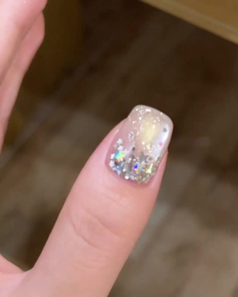 Vue en gros plan dun pinceau appliquant une fine couche de vernis gel blanc sur le bord libre dun ongle.