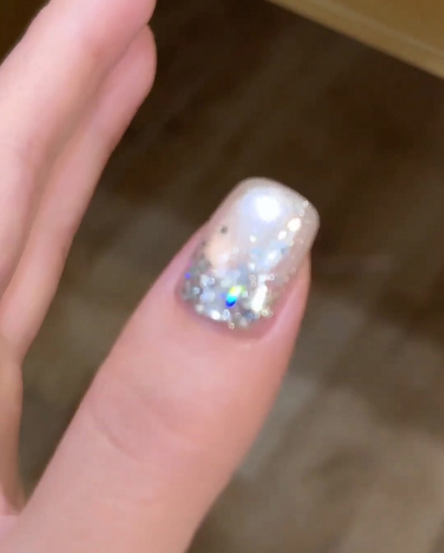 Un aimant tenu au-dessus dun ongle gel œil de chat humide pour manipuler les pigments métalliques en un motif circulaire.