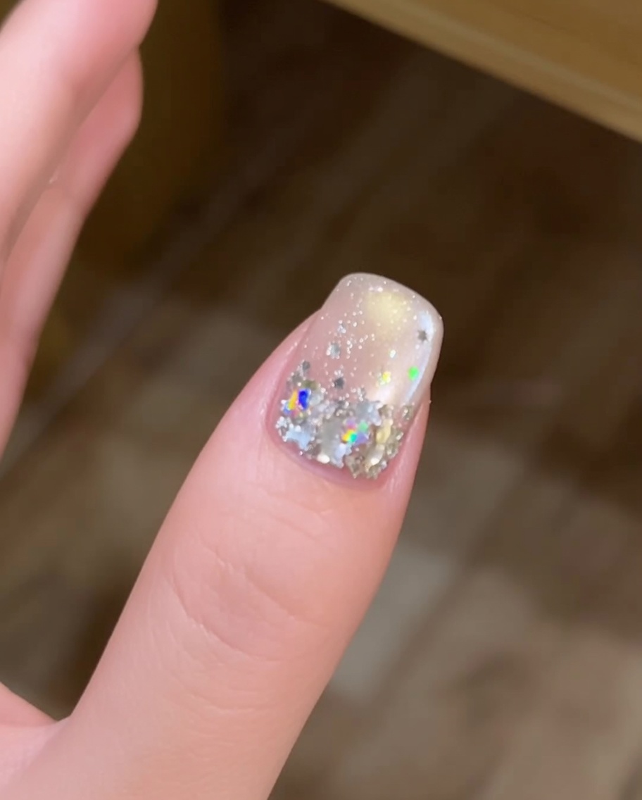 Un pinceau à ongle long appliquant une perle fraîche et arrondie de gel de construction transparent au centre de longle.