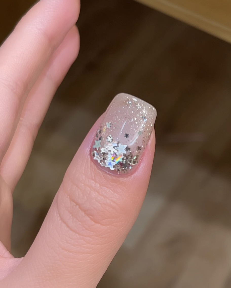 Vue en gros plan des ongles catalysant sous une lampe UV, signifiant lachèvement de lapplication.