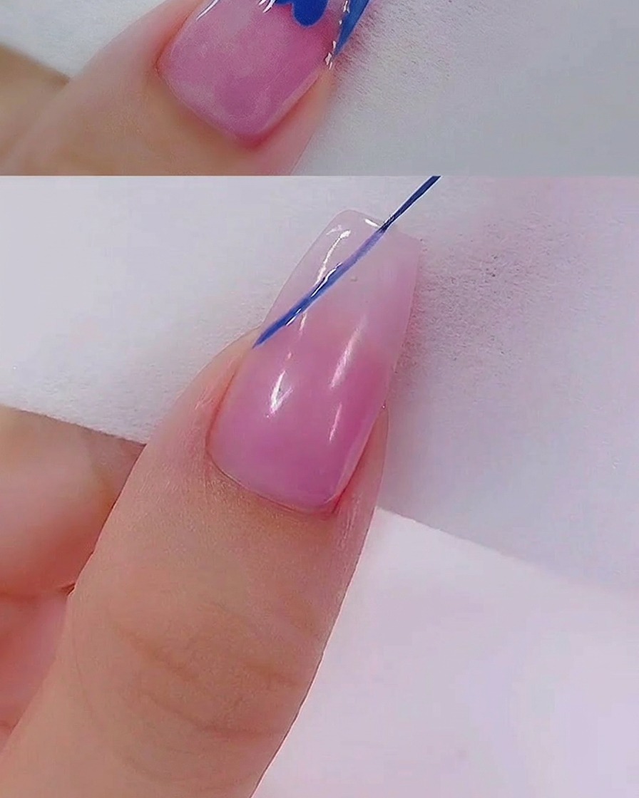 Un pinceau liner étirant soigneusement le gel bleu en forme de cœur sur la surface de longle.