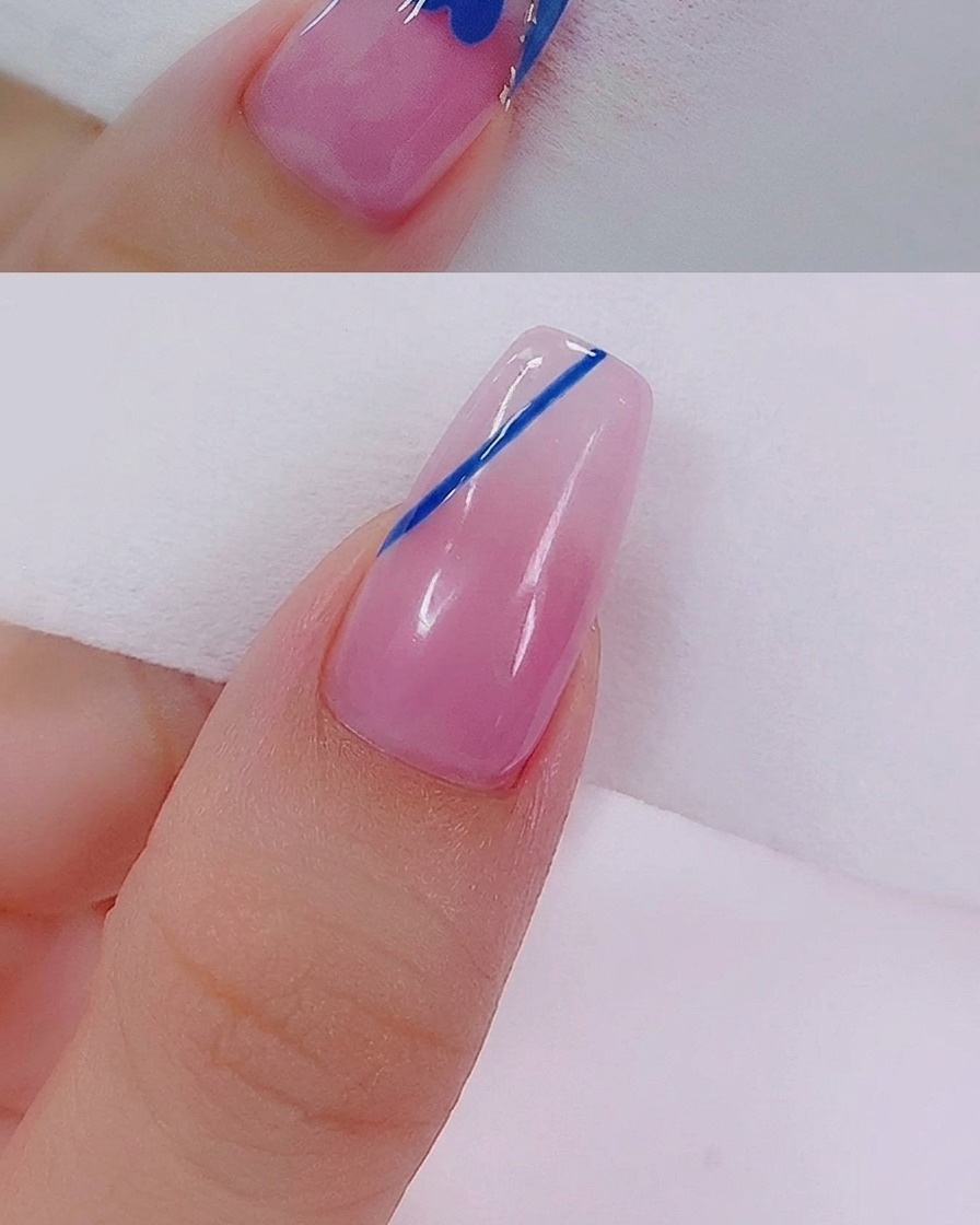 Gros plan dun cœur bleu en cours de remplissage avec du vernis bleu à laide dun pinceau nail art fin.