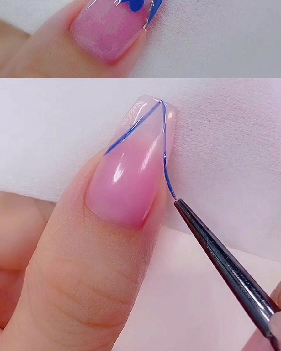 Un pinceau fin appliquant une fine ligne de gel pailleté or rose le long du bord dune French manucure.
