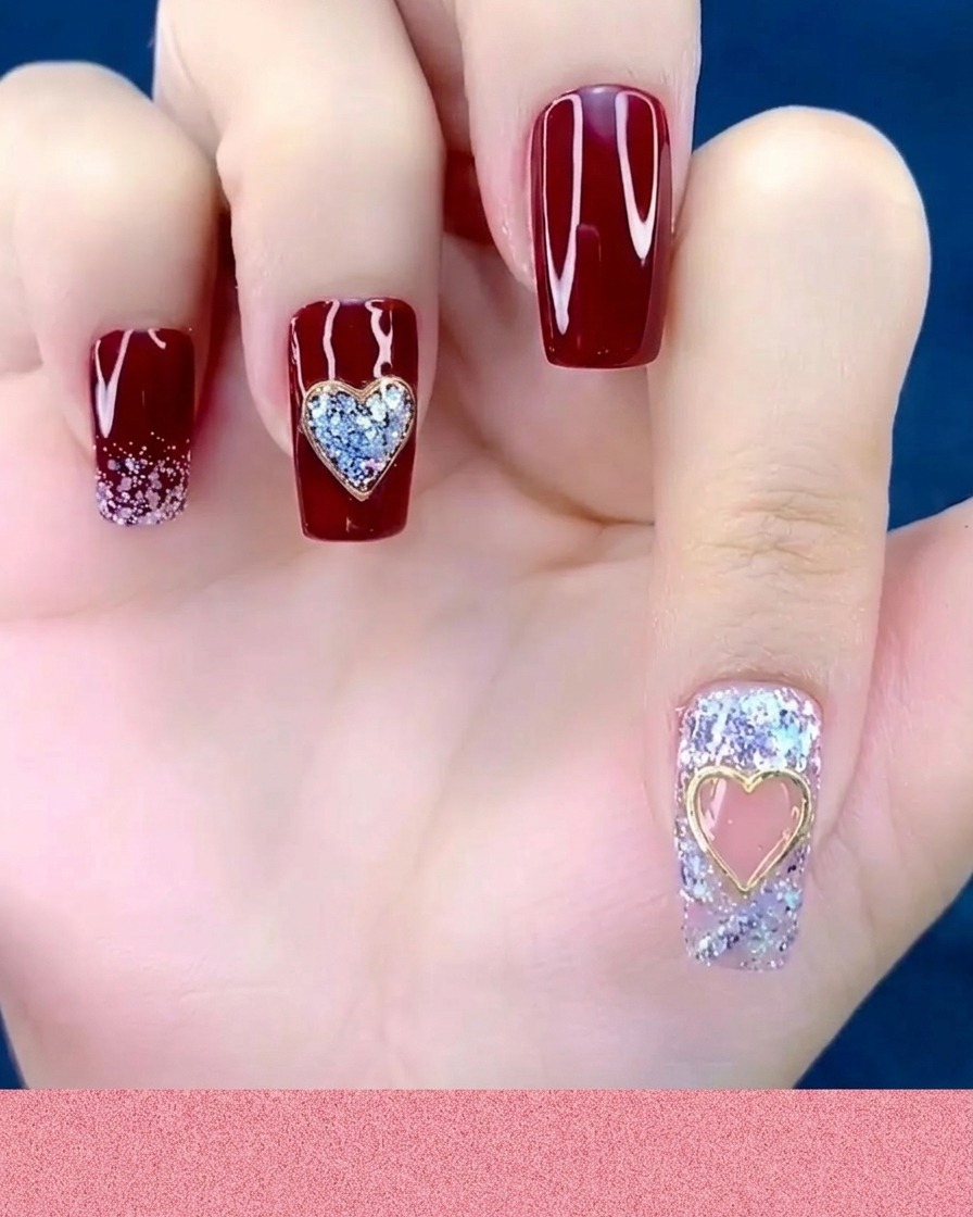 Un repousse-cuticules ou un outil en silicone appuyant sur un bijou cœur métallique posé sur un ongle.