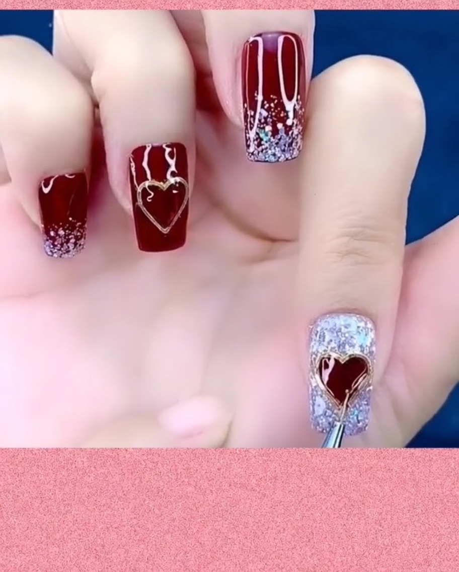 Un pinceau à nail art appliquant du top coat autour des bords dun bijou cœur métallique sur un ongle.