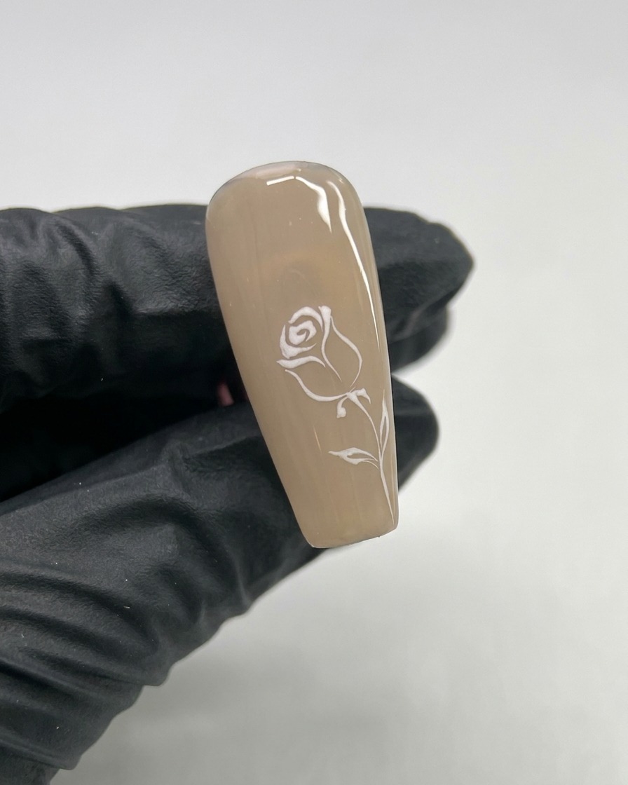 Gros plan dun ongle avec un petit cœur en gel blanc peint au centre.
