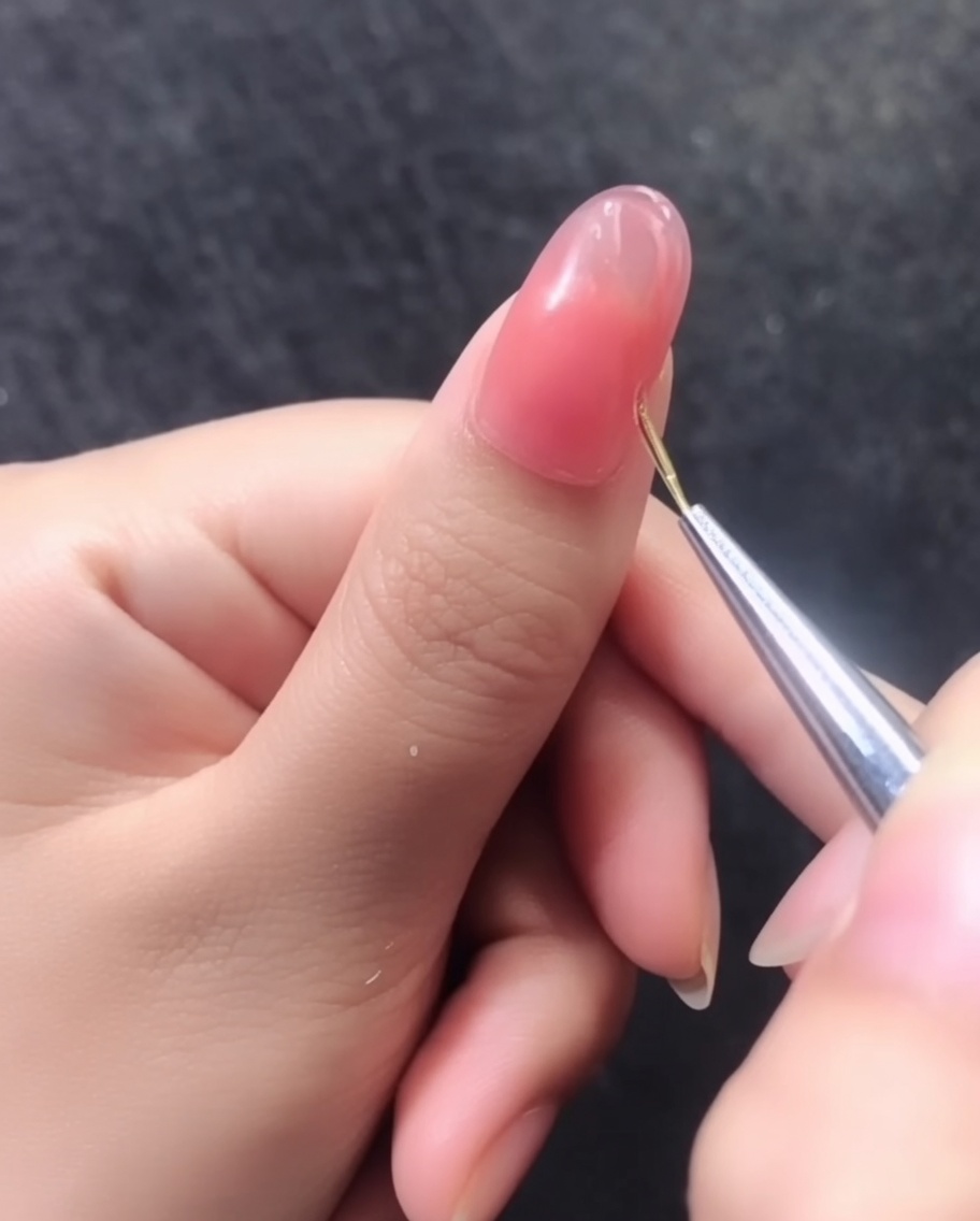 Vue détaillée dun motif de lignes dorées 3D terminé sur un ongle en gel rose.