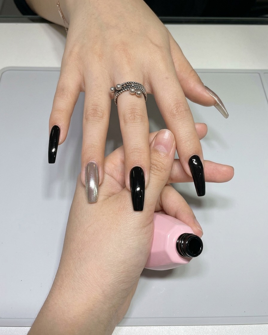 Gros plan dun pinceau liner fin pour nail art prélevant du vernis gel noir sur une petite palette.