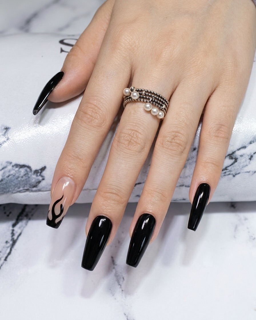 Gros plan dun pinceau liner redéfinissant les bords et les pointes dun motif de flamme noire sur un ongle chromé.