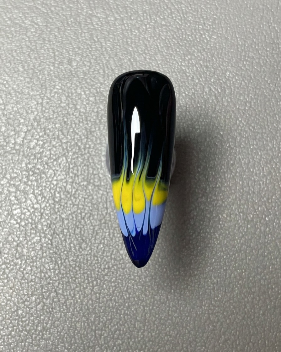 Une bande horizontale de vernis gel bleu appliquée sur le bout de longle à base noire.