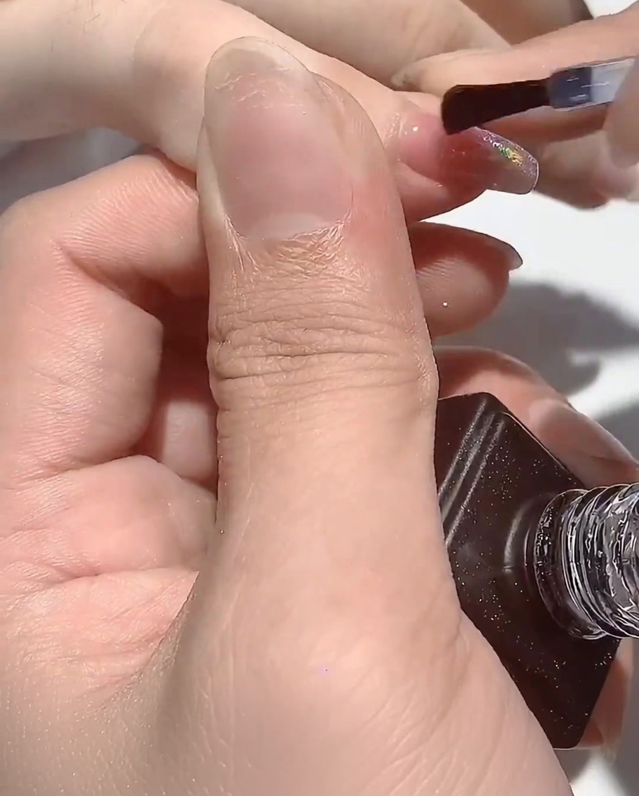 La main reposant sous la lampe UV avec les ongles en train de catalyser.