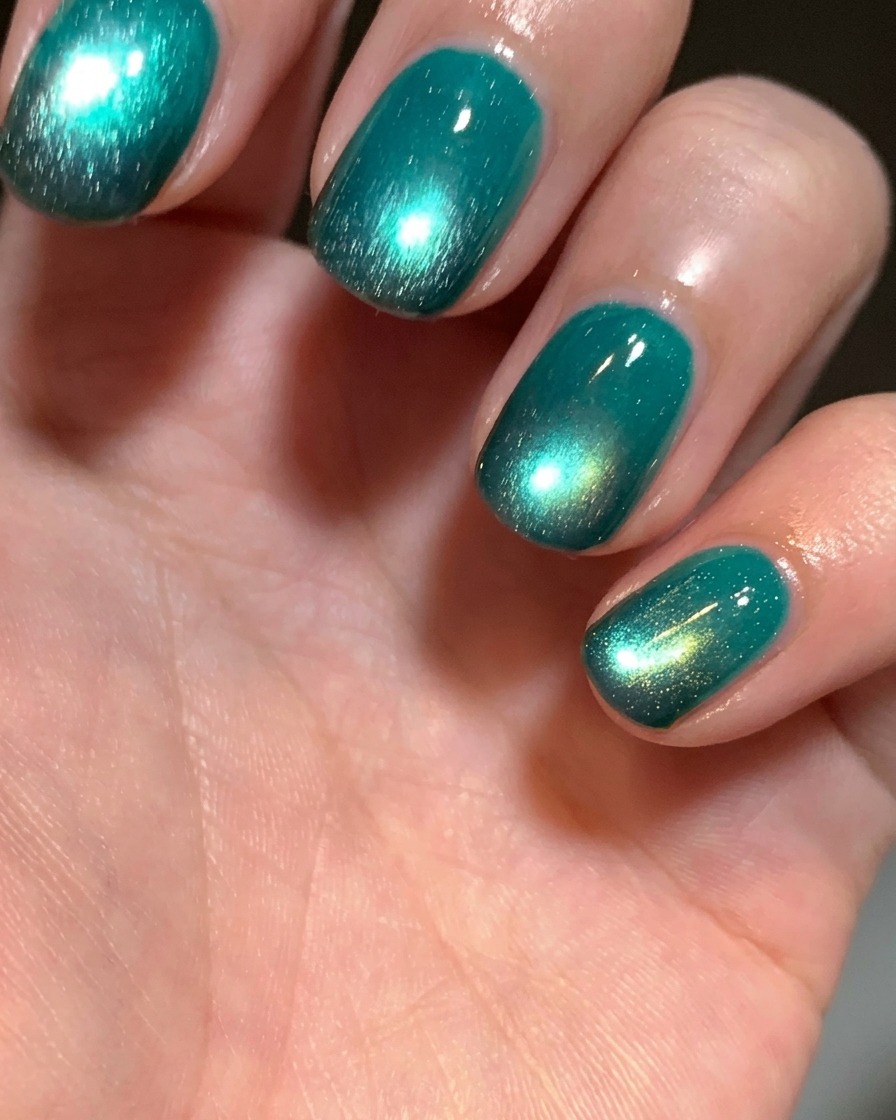 Gros plan sur le bout dun doigt où du gel noir est appliqué sur longle naturel à laide dune petite éponge cosmétique.