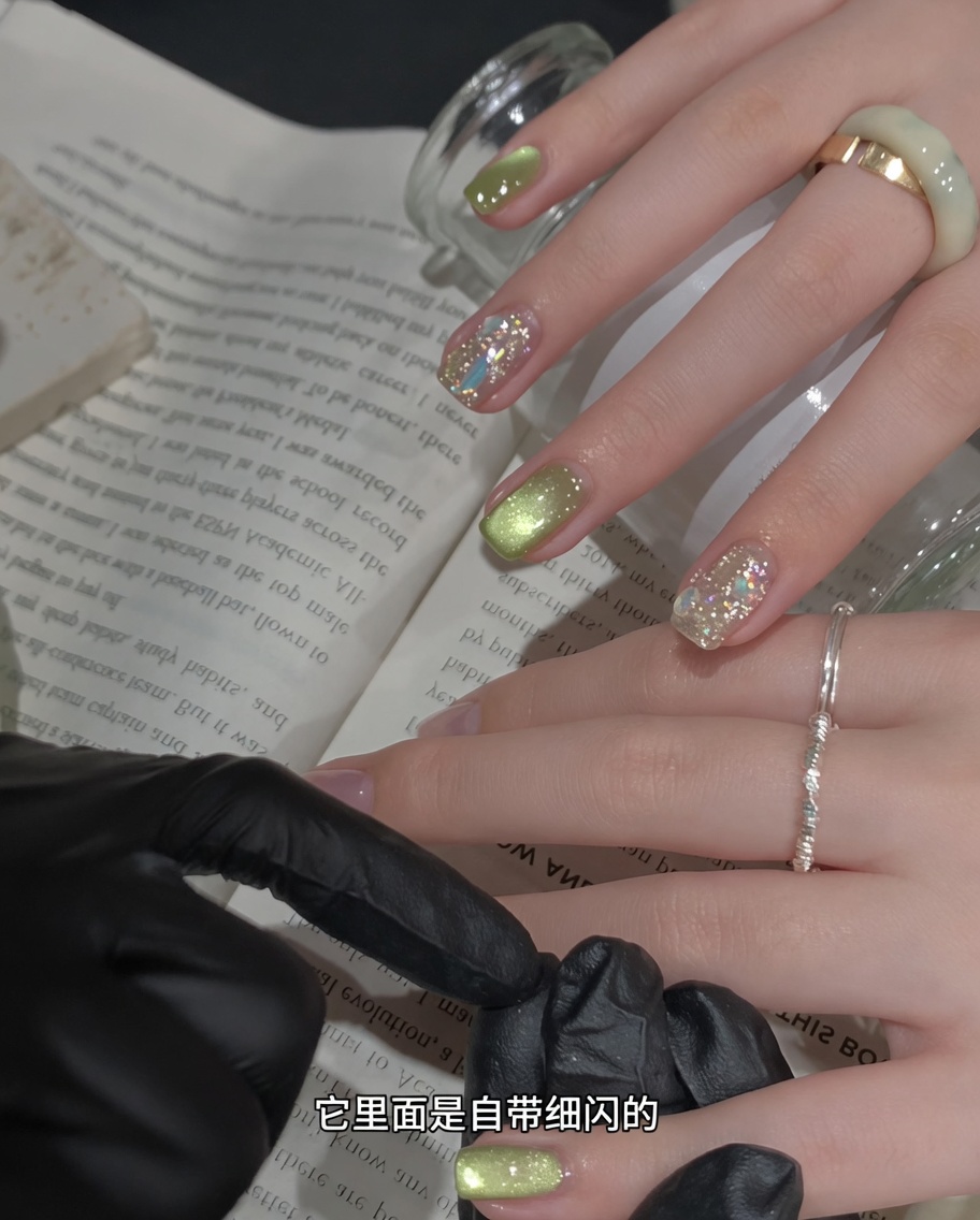 Un outil magnétique pour ongles tenu près dun ongle recouvert de gel vert scintillant humide pour manipuler les particules magnétiques.