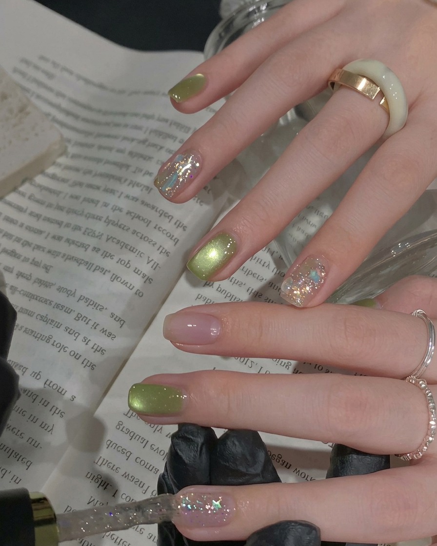 Un pinceau appliquant une couche de vernis gel à paillettes argentées denses et étincelantes sur un ongle en accent.