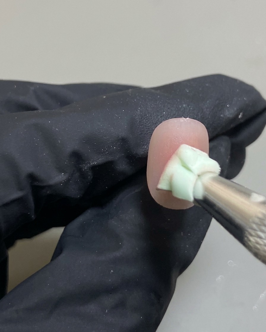Gros plan dun ongle avec une éponge estompant un point de gel rose pour créer un effet ombré blush.