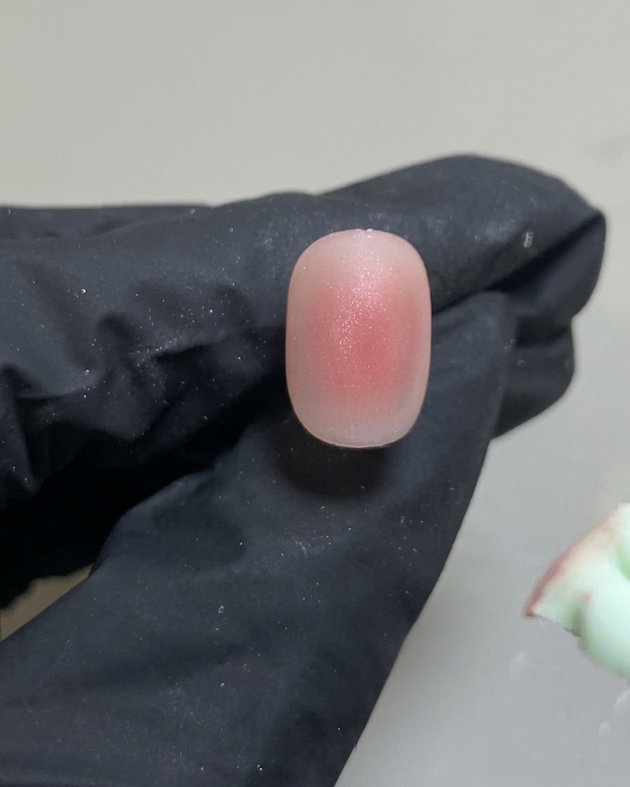 Un outil silicone déposant un petit point précis de gel rose au centre de longle.