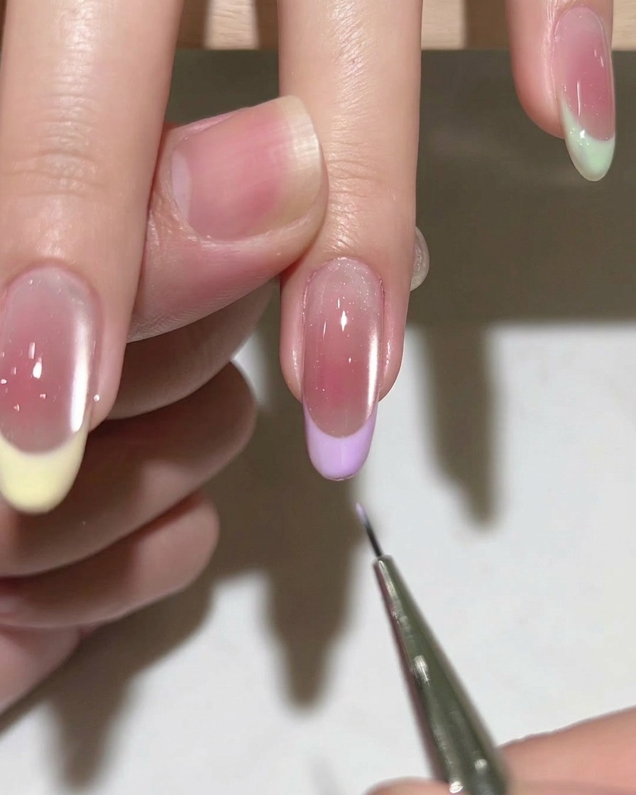Gros plan sur un pinceau appliquant une base gel transparente sur un ongle naturel préparé.