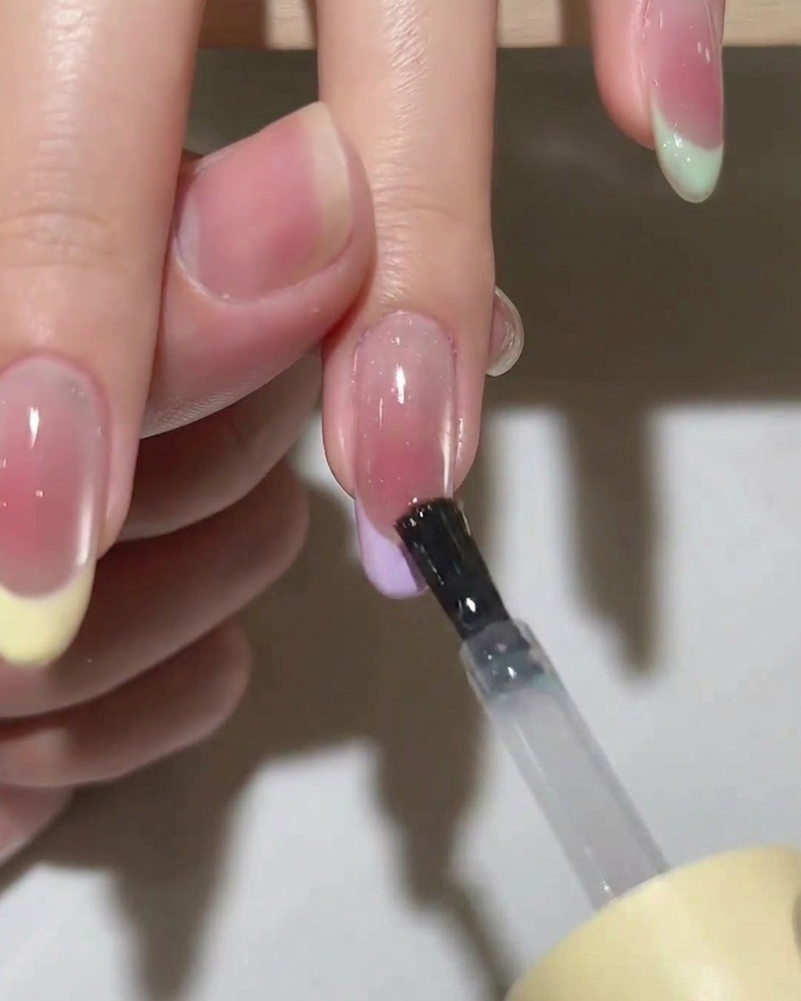Une main placée dans une lampe UV/LED allumée pour catalyser le vernis.