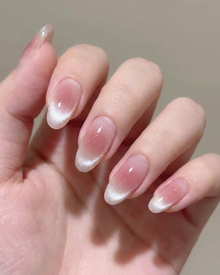Application dune seconde couche de vernis gel rose transparent sur longle.