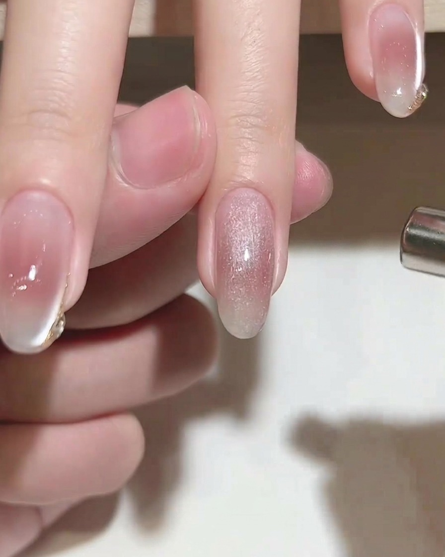 Un aimant cylindrique maintenu au-dessus dun ongle recouvert de gel cat-eye humide pour créer un effet scintillant.