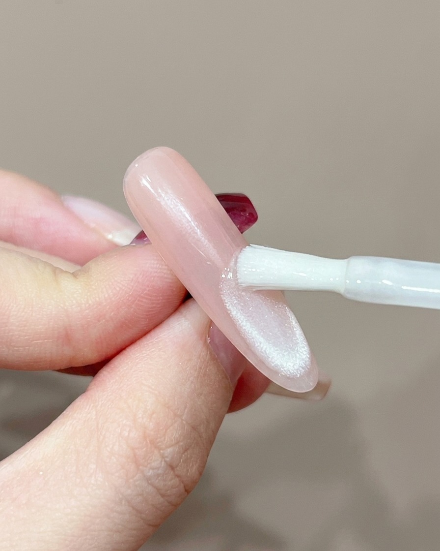 Un ongle positionné sous une lampe UV professionnelle pour la catalysation.