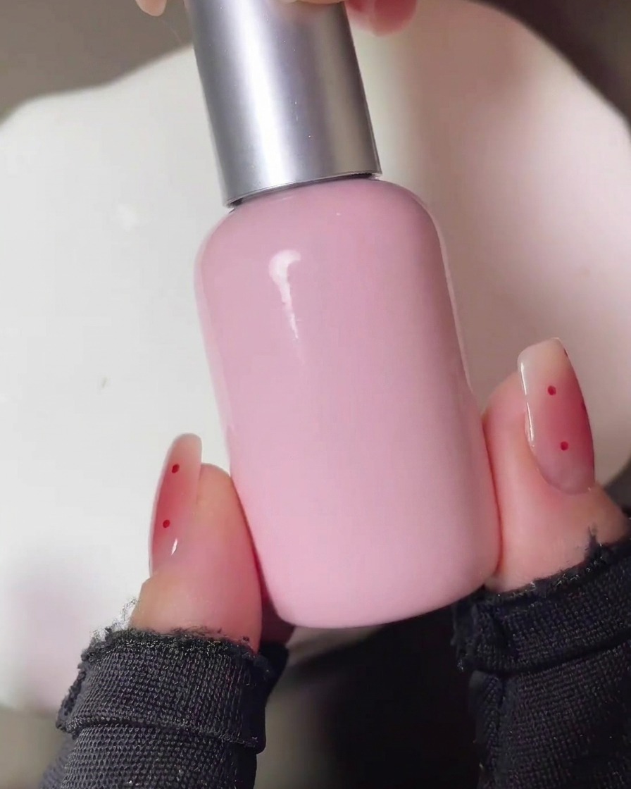Les ongles catalysés sous une lampe UV après lapplication initiale du pigment blush rouge.