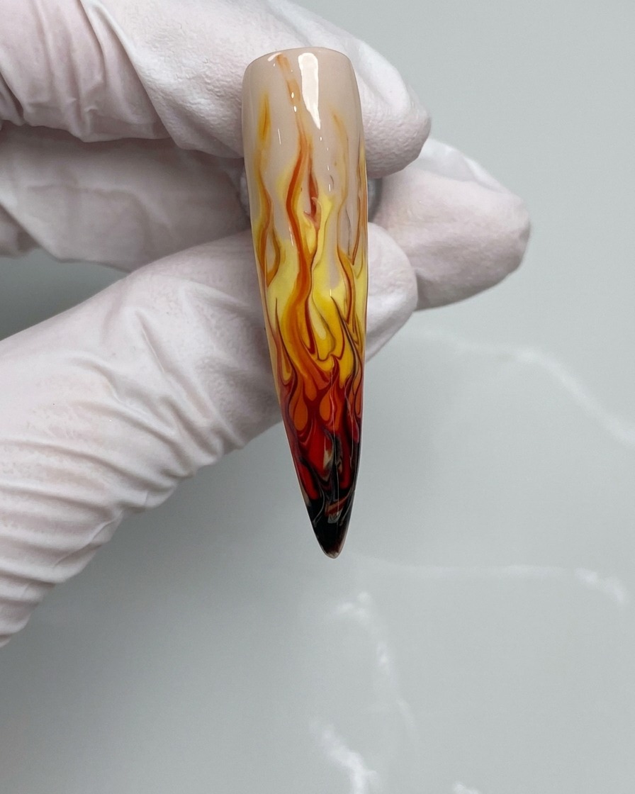 Un pinceau à ongles appliquant du vernis gel noir sur le bout dun ongle.