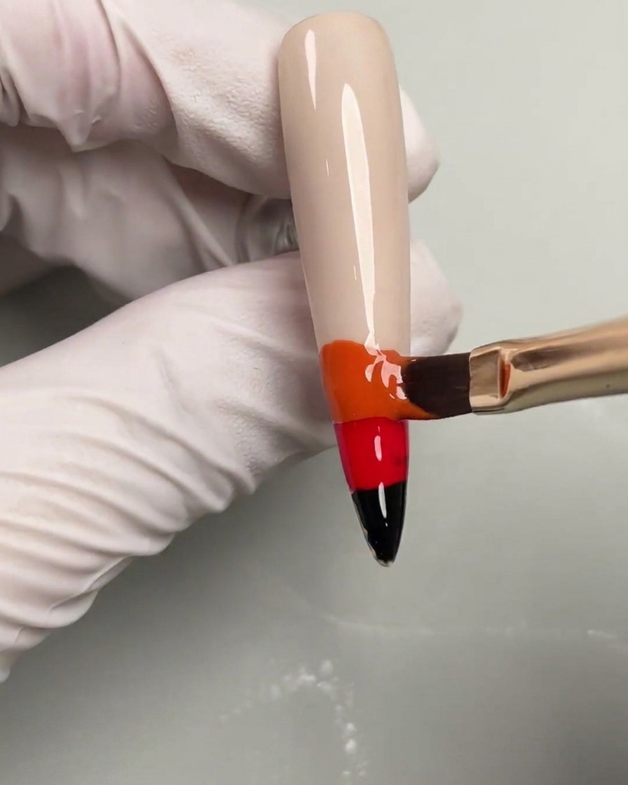 Vernis gel jaune appliqué en haut du dégradé de couleurs sur un ongle.