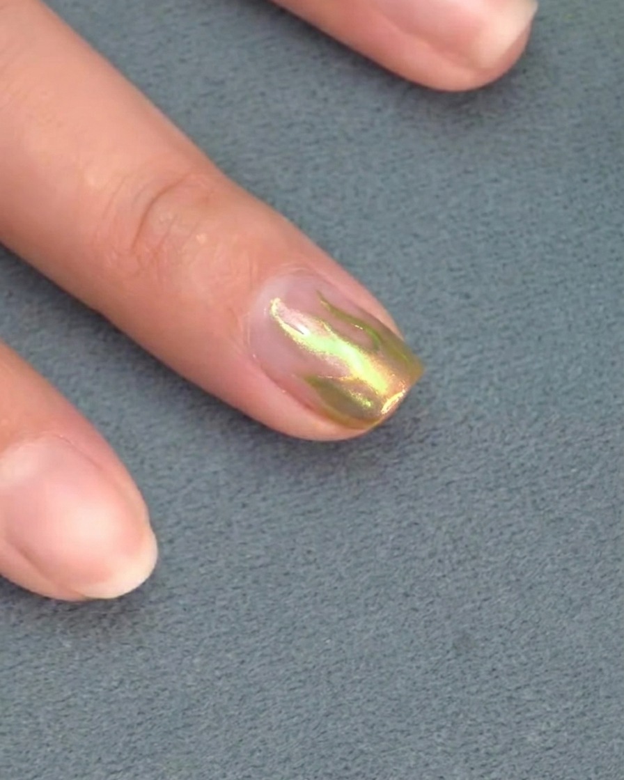 Gros plan dun pinceau liner perfectionnant la pointe acérée dune flamme sur un ongle.