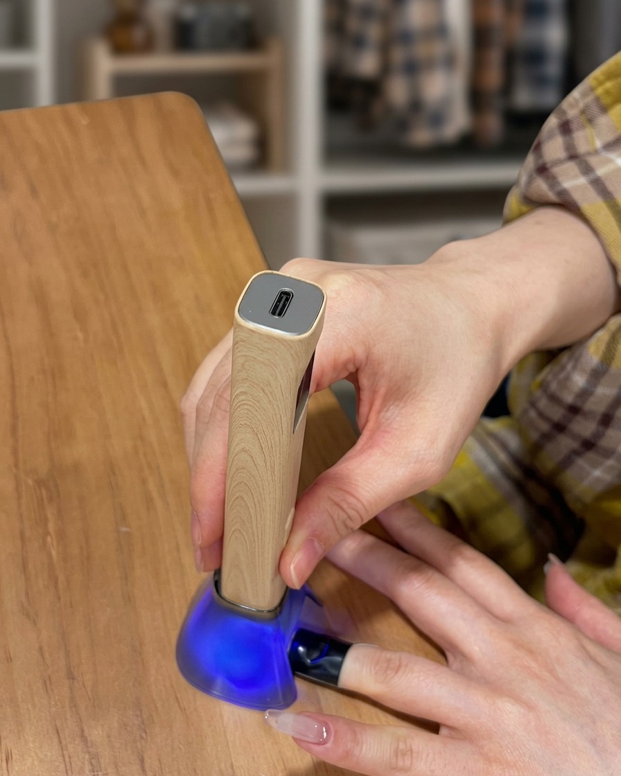 Un doigt posé dans une lampe UV pendant la catalysation du top coat.