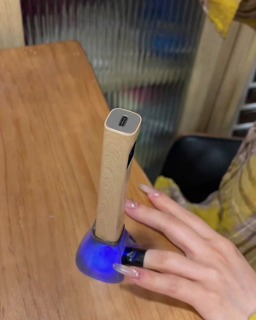 Un doigt avec un strass posé dans une lampe UV pour catalyser.
