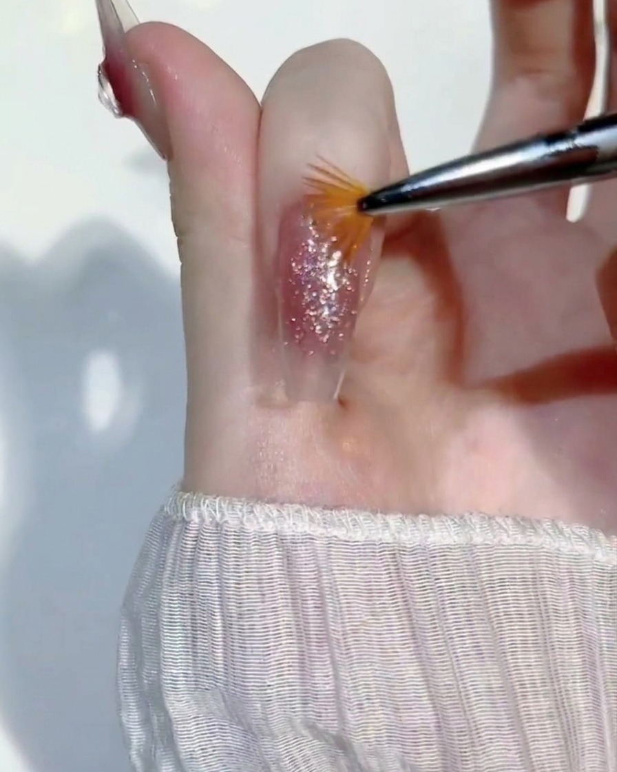 Passage léger dun mini pinceau éventail sur le gel pailleté humide.