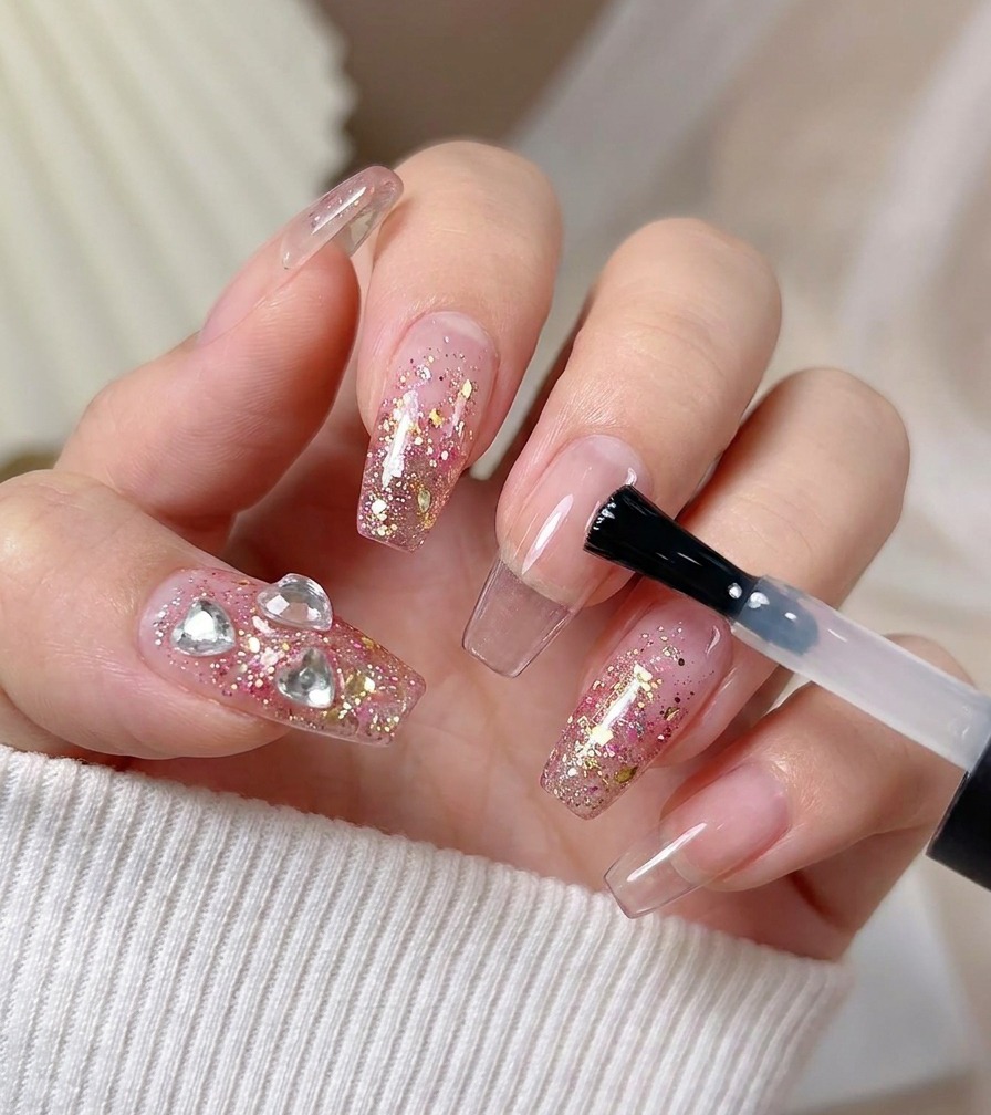 Pinceau appliquant un top coat brillant sur un ongle décoré.