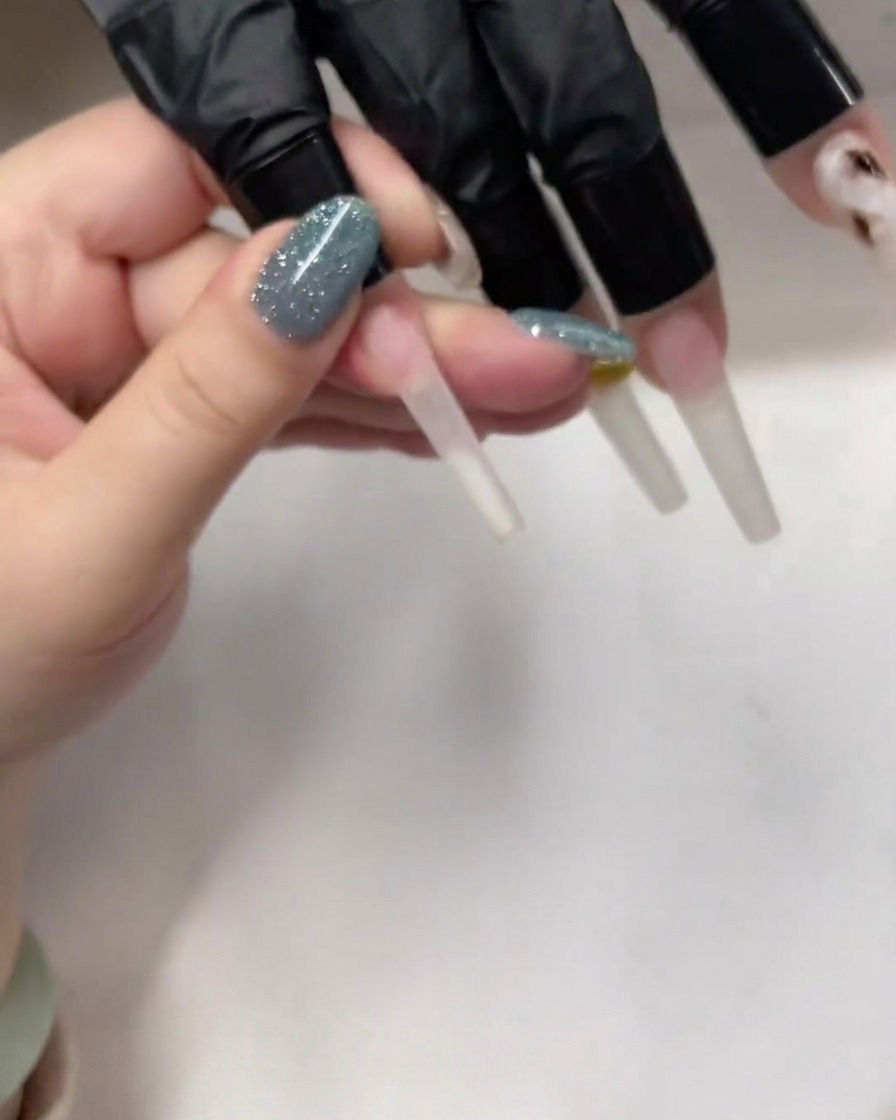 Un pinceau appliquant une fine base de gel sur un ongle cercueil.